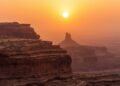 Lucid origin photograph of layered sandstone cliffs under a hazy sunset burnt sienna and mute 0.jpg