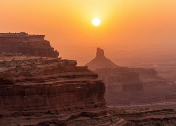 Lucid origin photograph of layered sandstone cliffs under a hazy sunset burnt sienna and mute 0.jpg
