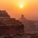 Lucid origin photograph of layered sandstone cliffs under a hazy sunset burnt sienna and mute 0.jpg